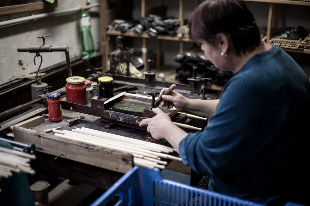 Na fotografii nanáší na paličku pracovnice prostřednictvím sítotisku jméno bubeníka. Ti je zpravidla po koncertě odhazují mezi fanoušky, kterým tak zůstane připomínka