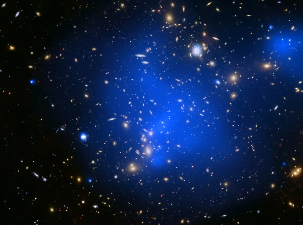 Klastr galaxií Abell 2744 s rozehřátým plynem, který září modře, je zachycen na kombinovaném rentgenovém a optickém snímku