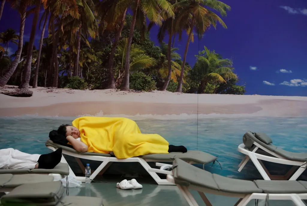 Žena, která zdánlivě relaxuje na pláži, je zdravotní sestra odpočívající v moskevské polní nemocnici. Ta byla otevřena pro pacienty s onemocněním covid-19