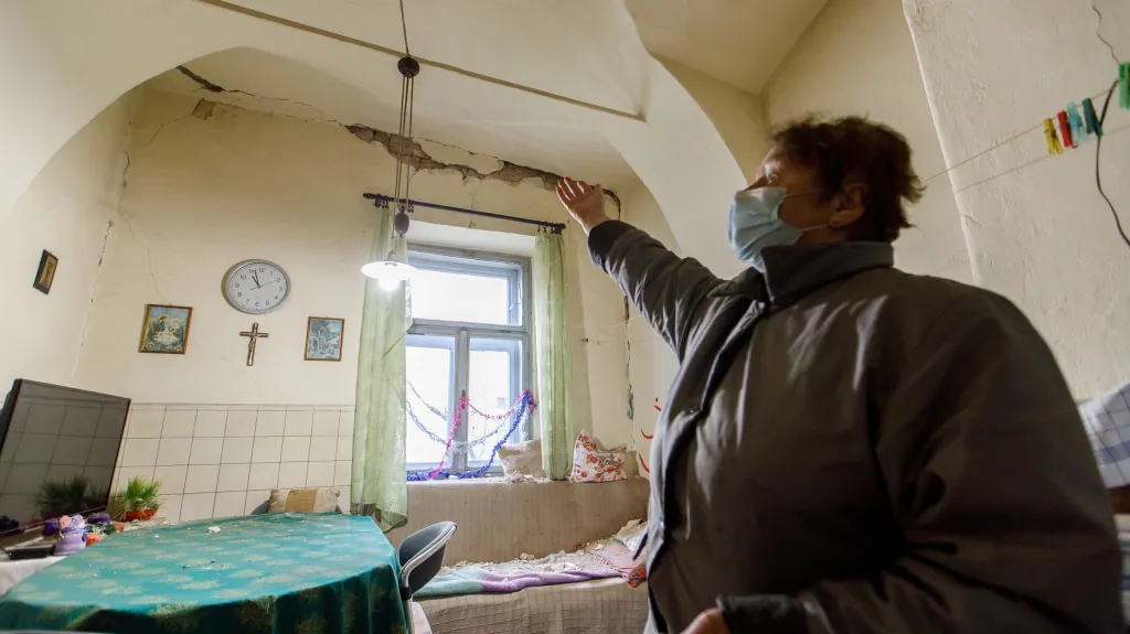 Obyvatelka města Petrinja, nedaleko od epicentra zemětřesení, ukazuje na puklinu ve zdi