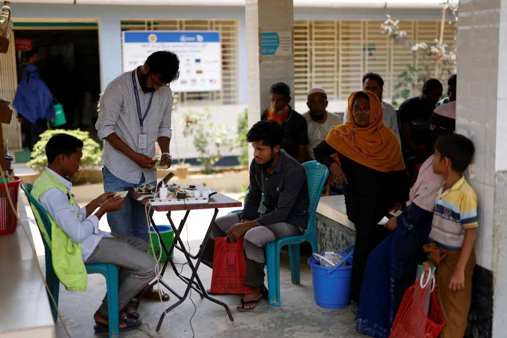 Úředníci kontrolují doklady rohingských uprchlíků v distribučním centru