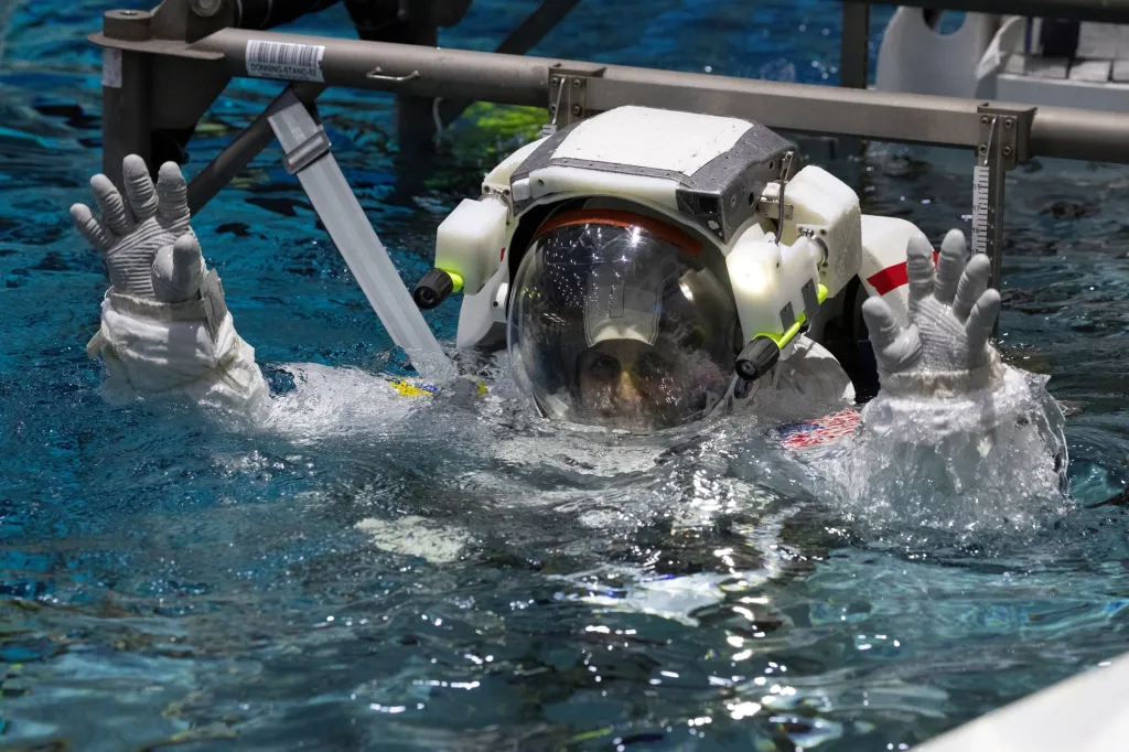 Astronautku Sunitu Williamsovou spouští do vody v tréninkovém bazénu