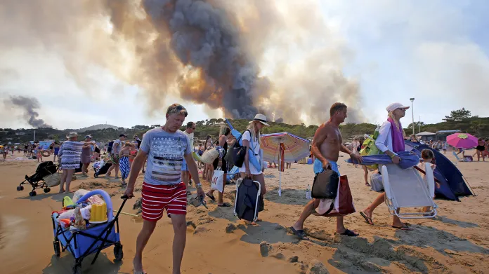 Turisté evakuovaní z pláží francouzské Riviéry po tom, co lesní požáry zachvátily kopce oblasti nedaleké Bormes-les-Mimosas v jižní Francii.