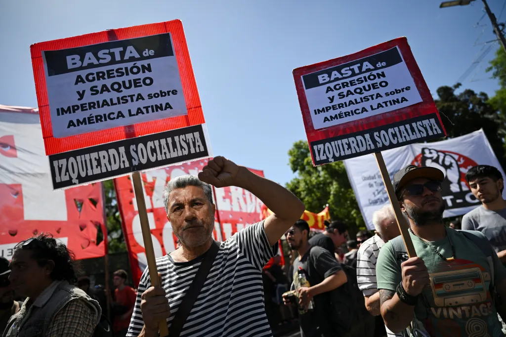 Protest v Buenos Aires proti americkým úderům ve Venezuele (muž vlevo drží nápis „Dost imperiální agrese a drancování Latinské Ameriky“)