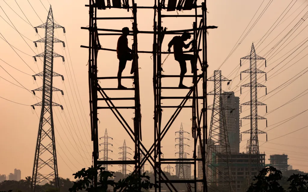Dělníci v indické Bombaji připravují na lešení z bambusu stavbu stožárů vysokého napětí