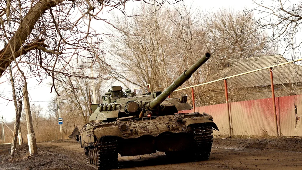 Ukrajinský voják gestikuluje v tanku na silnici směrem k Bachmutu