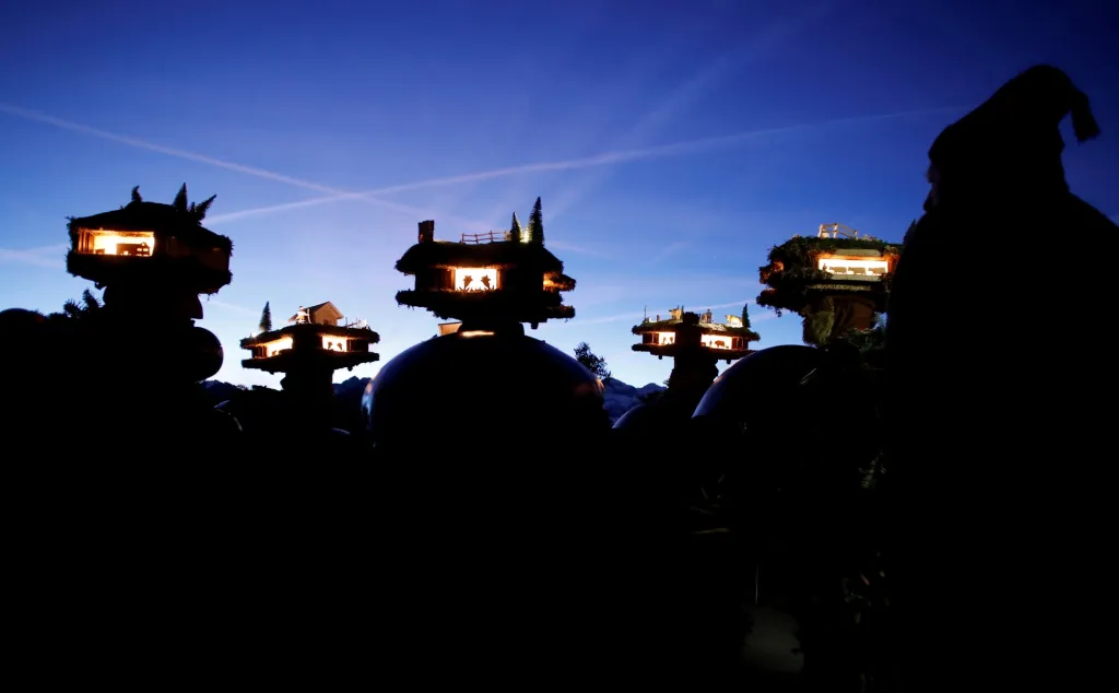 Muži oblečení v kostýmu postaviček "Chlaeuse"putují vesnicí Urnaesch ve Švýcarsku