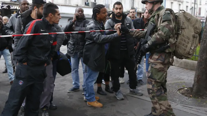 Policista legitimuje obyvatele Saint-Denis po razii v listopadu 2015