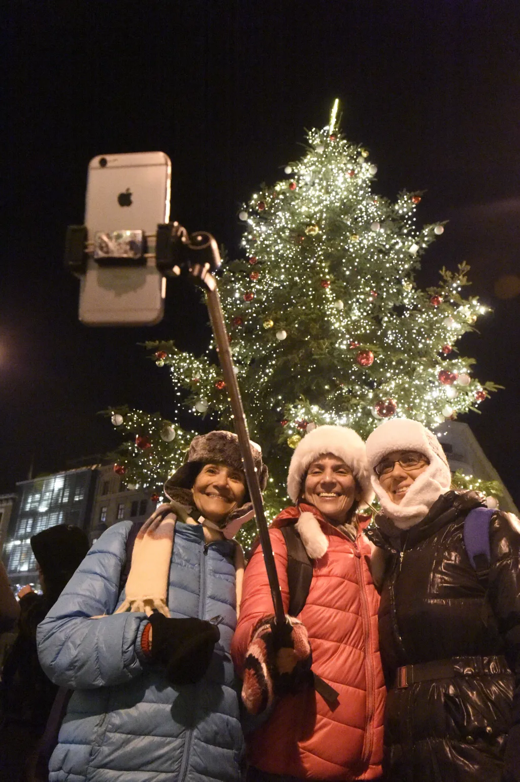 Návštěvnice vánočních trhů v Brně se fotografují před rozsvíceným stromečkem