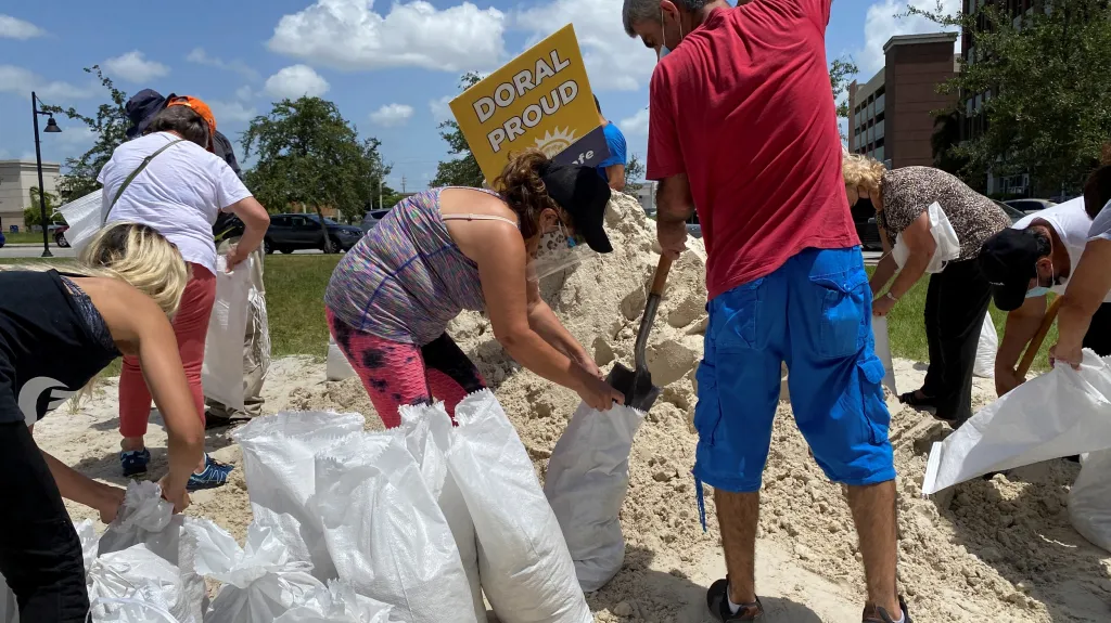 Lidé ve floridském městě Doral plní pytle s pískem
