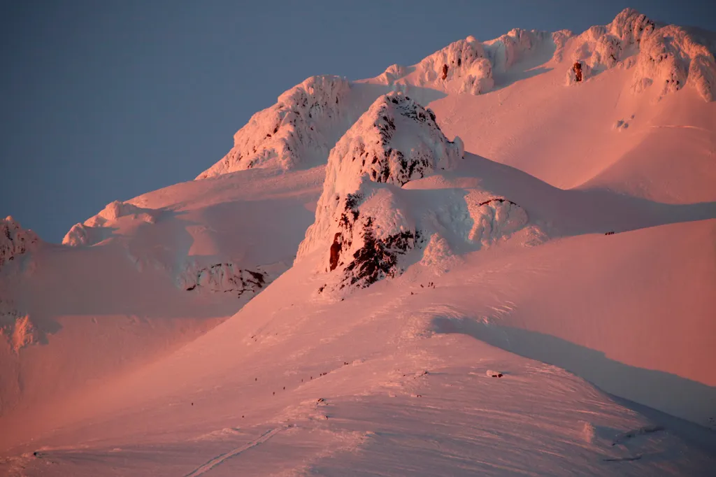 Západ slunce a sestup horolezců a záchranářů z hory Mount Hood, ve státě Oregon, USA.
