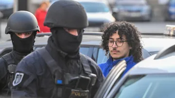 Policisté přivádějí muže v poutech k Okresnímu soudu v Pardubicích, který rozhodoval o vazbě pro obviněné v souvislosti s úmyslným zapálením haly zbrojovky, 24. března 2026