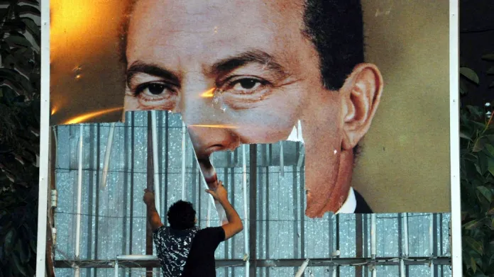 Demonstrant strhává plakát Mubaraka