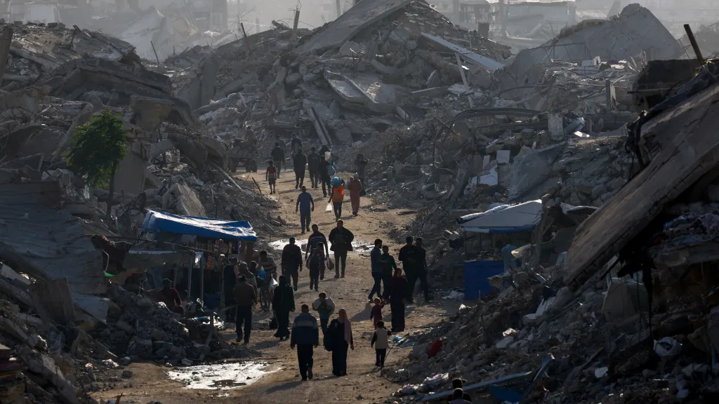 Palestinci se procházejí mezi hromadami sutin (19. listopadu 2025)