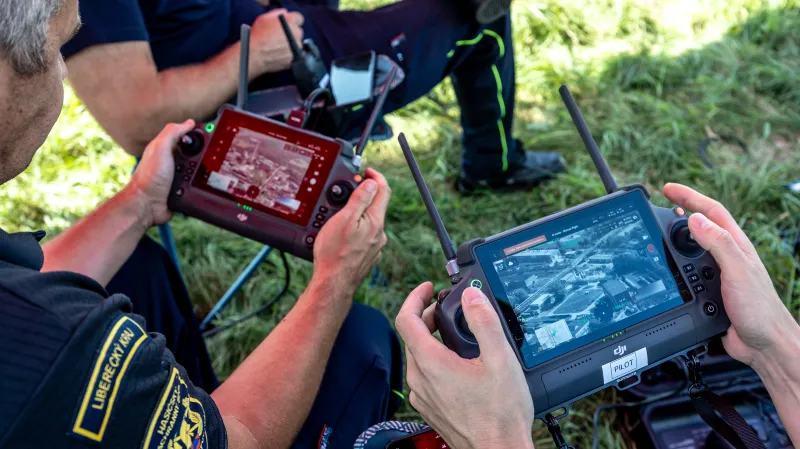 Operátoři dronů poblíž závodu společnosti Orlen Unipetrol před odpálením letecké pumy z druhé světové války