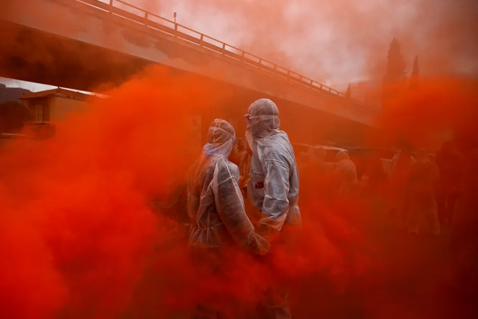 Dva návštěvníci obklopeni nasvíceným červeným kouřem během tradičních oslav tzv. Popelečního pondělí, kterým se označuje konec karnevalové sezony a začátek 40denního období půstu v řeckém městě Galaxidi
