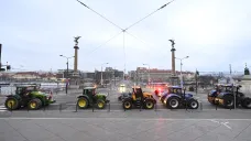 Protestující zemědělci projíždí kolem Čechova mostu v Praze