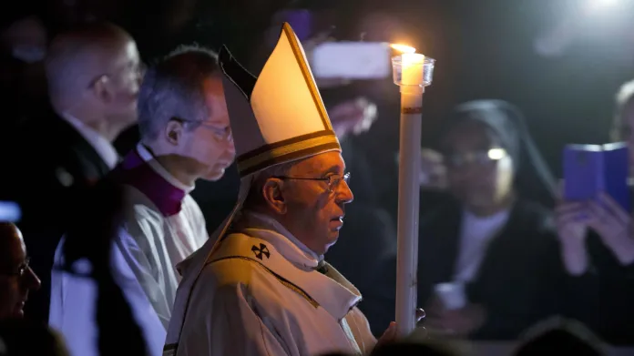 Papež František přichází s bílou svící na velikonoční vigilii