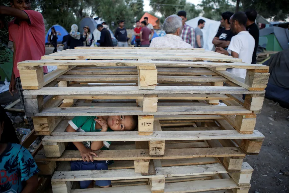 V uprchlickém táboře Moria na řeckém ostrově Lesbos si hraje malý chlapec v dřevěných paletách