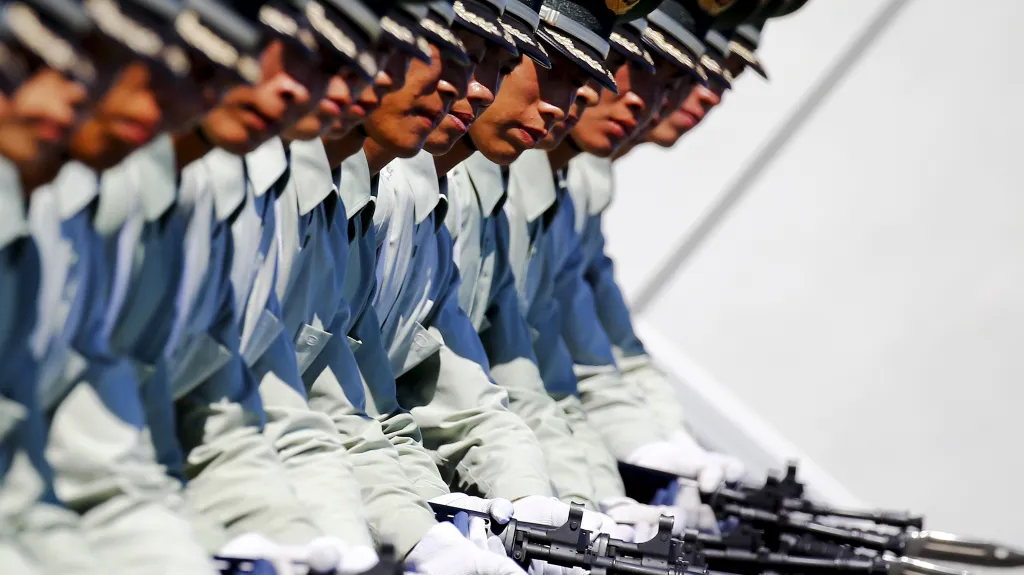 Vojáci čínské lidové osvobozenecké armády pochodují se zbraněmi během nácviku na vojenskou přehlídku