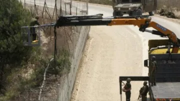 Izraelský ženista opravuje hraniční plot s Libanonem