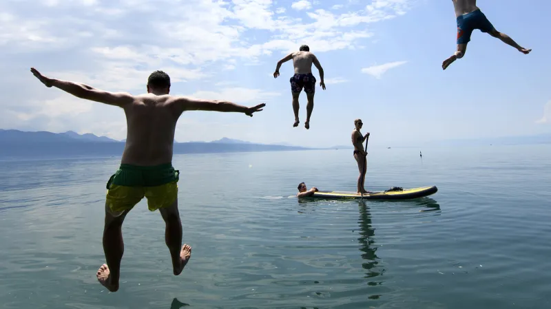 Lidé na paddleboardech si užívají teplého a slunečného počasí na Ženevském jezeře ve Švýcarsku