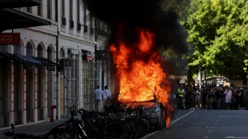 Zapálené auto při protestech v Ženevě proti nadcházejícímu summitu G7