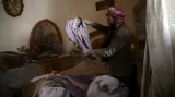 Muž v domě na předměstí Damašku prohlíží tričko svého mrtvého syna, který zahynul 26. února při leteckém útoku na rebely ovládané město Douma
