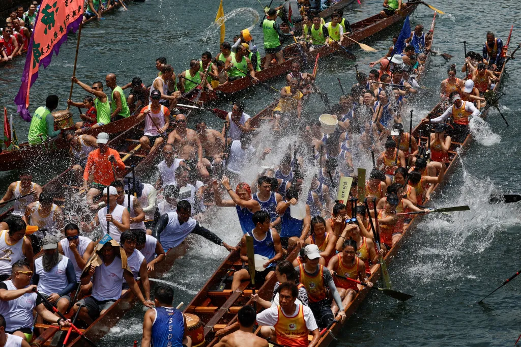 Účastníci stříkají vodu během obřadu mezi závody během festivalu Tung Ng neboli Festivalu dračích lodí v rybářském přístavu Aberdeen v Hongkongu