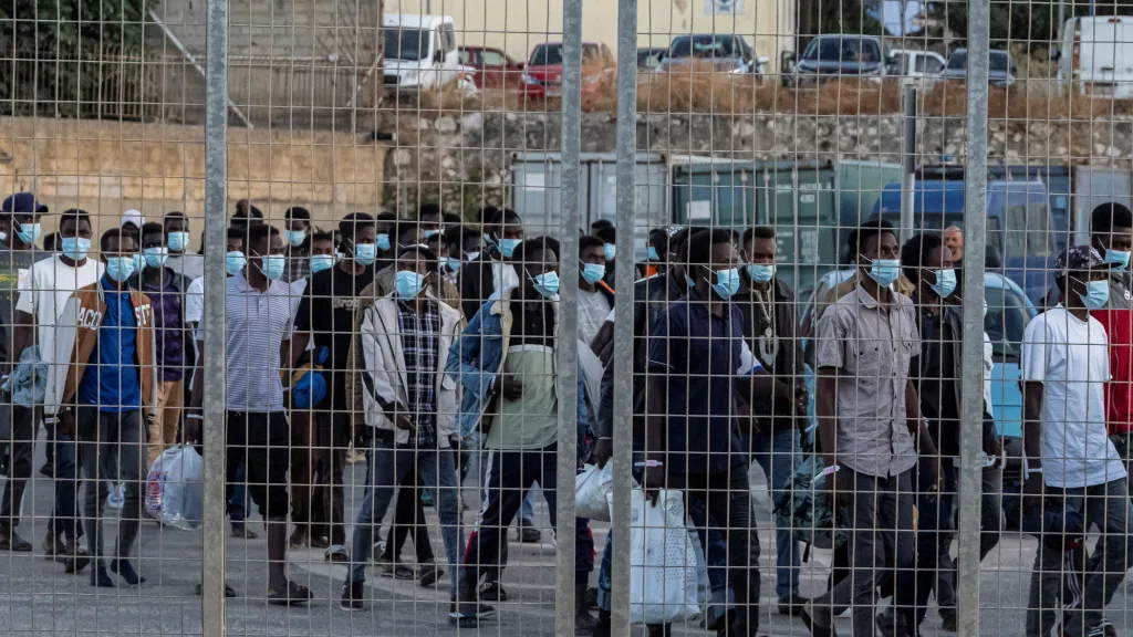 Skupina nově příchozích migrantů v přístavu Souda na cestě k trajektu do pevninského Řecka