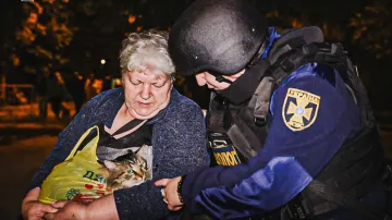 Pracovník záchranné služby asistuje po zásahu ruského dronu