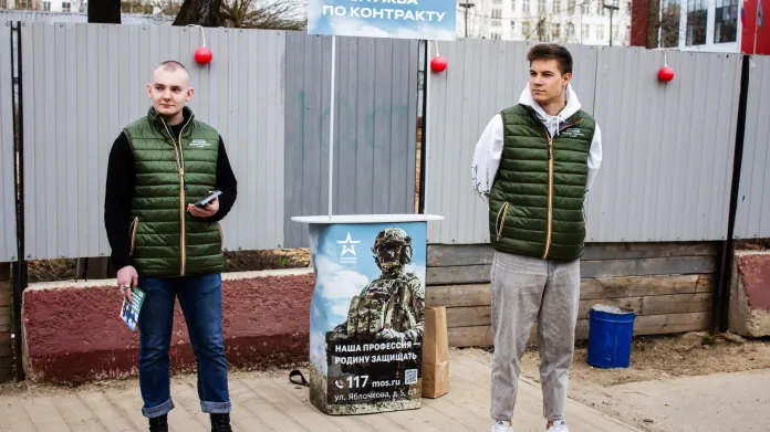 Dobrovolníci rozdávají letáky k náboru do ruské armády u vlakové zastávky v Moskvě