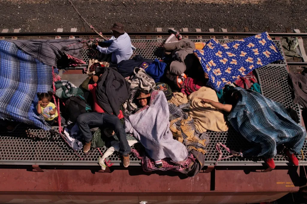 Migrující lidé ležící na střeše nákladního vozu