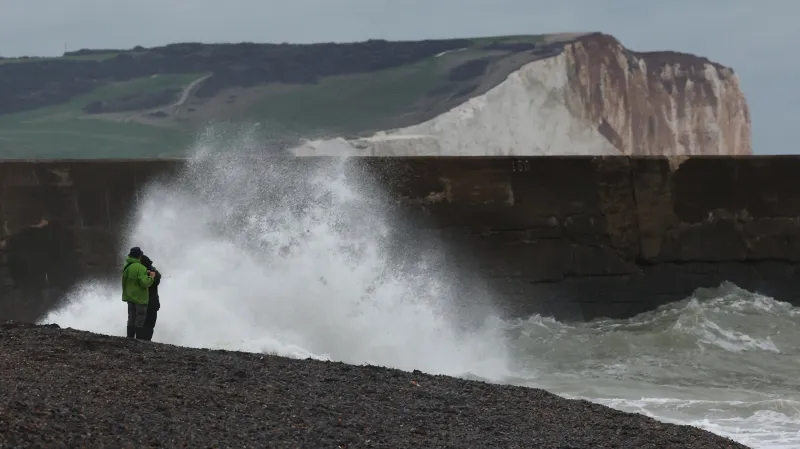 Lidé stojí poblíž pobřeží v britském Newhavenu (23. října 2025)