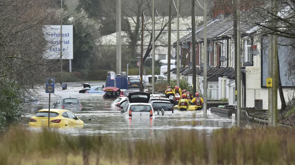 Lidé před zatopeným domem na Oxford Street v Nantgarw ve Walesu.