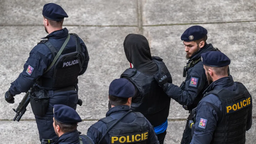 Eskorta odvádí od Okresního soudu mladíka obviněného z vraždy dvou žen, 21. února 2025