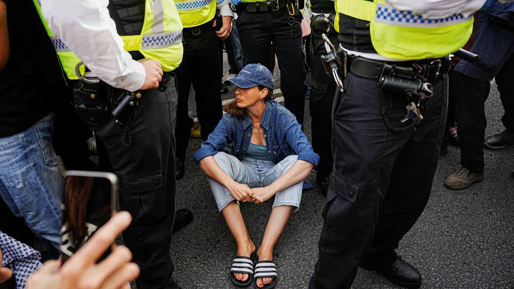 Účastnice londýnské demonstrace obklopená policisty