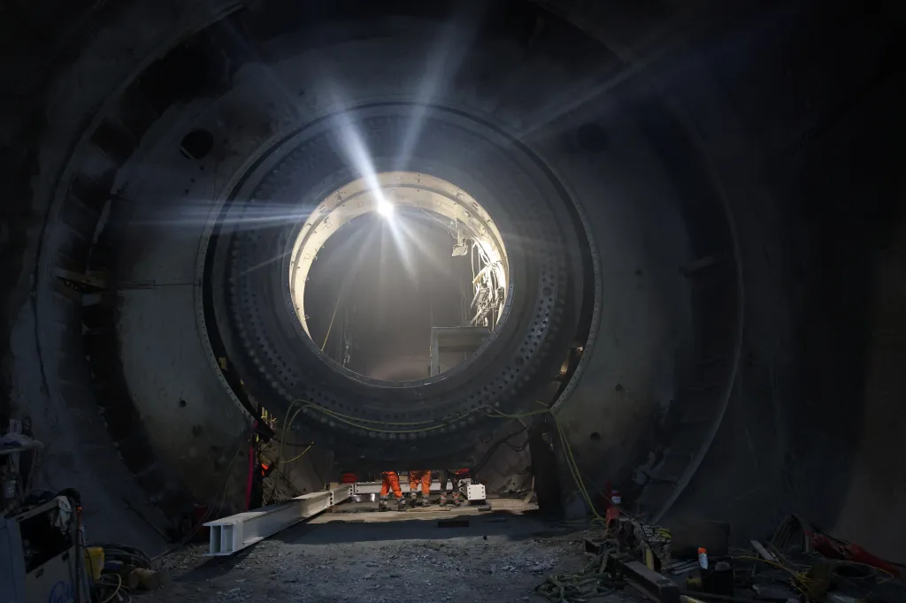 Dva tunelovací stroje, každý s vrtným průměrem přibližně 10,5 metru, mají celkovou délku přibližně 160 metrů, což odpovídá délce dvou fotbalových hřišť. Tyto stroje jsou v podstatě pojízdné továrny, které během výkopových prací také instalují prvky tunelu