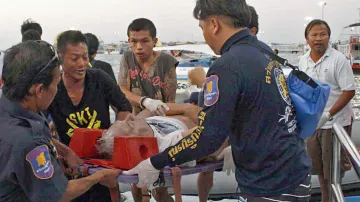 Thajští záchranáři se zraněným turistou z potopené lodi
