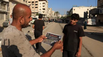 Obyvatel města Gaza s letákem, který obsahuje výzvu k evakuaci