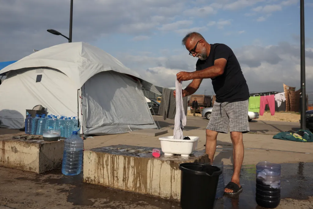 Uprchlík z jižního předměstí Bejrútu si pere šaty v improvizovaném uprchlickém táboře