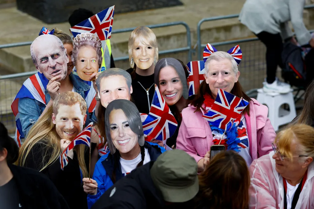 Lidé s maskami členů britské královské rodiny