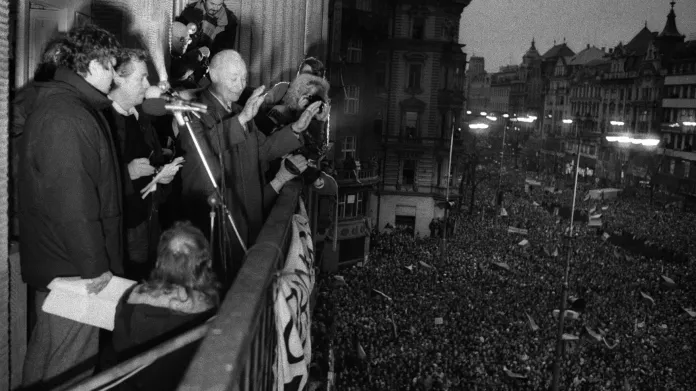 Alexander Dubček mává z balkonu Melantrichu účastníkům demonstrace 23. listopadu 1989. Po jeho boku stojí Václav Havel a Václav Malý.