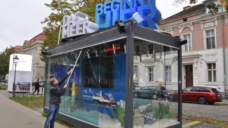 Pracovník městských služeb dezinfikuje výlohu jednoho z prosklených pavilonů v Postupimi