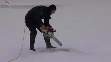 Potápěč vyřezává díru v ledu