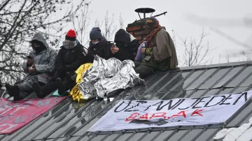 Demonstranti na střeše domu v osadě Bedřiška