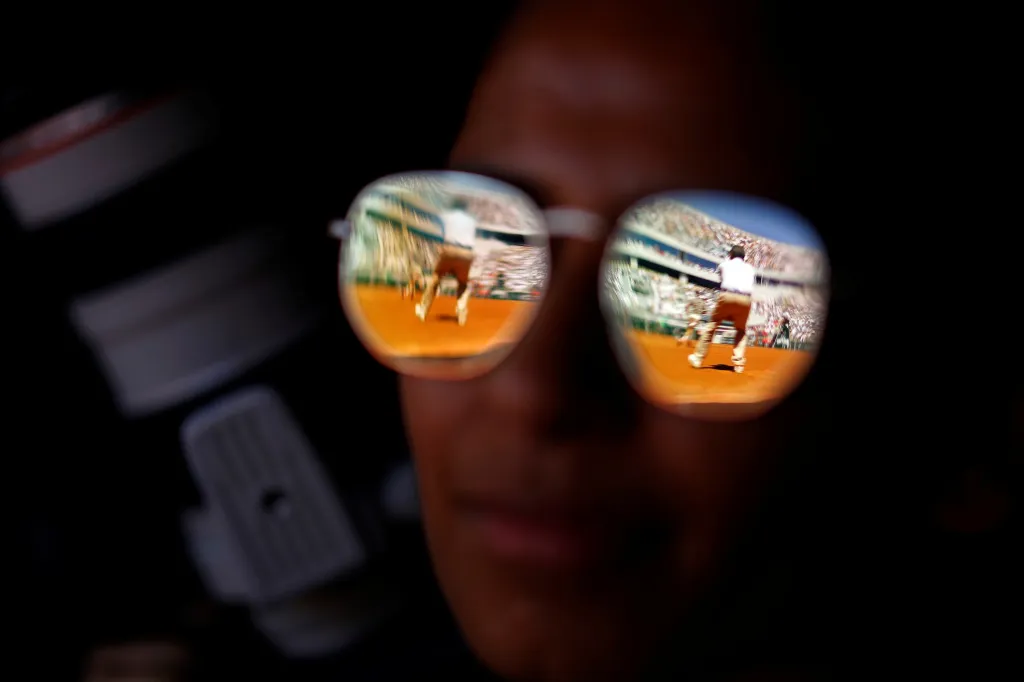 Na tenisovém Roland Garros jeden z fanoušků sleduje zápas téměř „detektivním okem“  mezi švýcarským Rogerem Federerem a Leonardem Mayerem