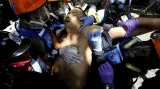 Zraněný muž v rukou zdravotníků při demonstraci proti venezuelskému prezidentovi Nikolasi Madurovi a jeho vládě v Caracasu.