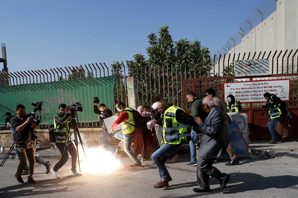 Palestinští novináři uskakují před omračujícím granátem na Západním břehu Jordánu