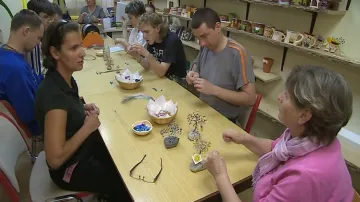 Klienti vyrábějí z navlečených korálků stromky štěstí